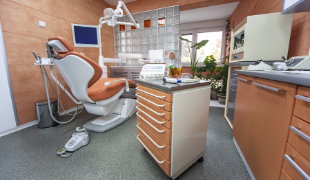A dental office that contains a dental chair and other dental equipment.
