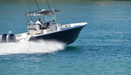 A small, motorized fishing boat on blue water.