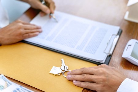A person signs the lease for an apartment and the property manager hands over the keys